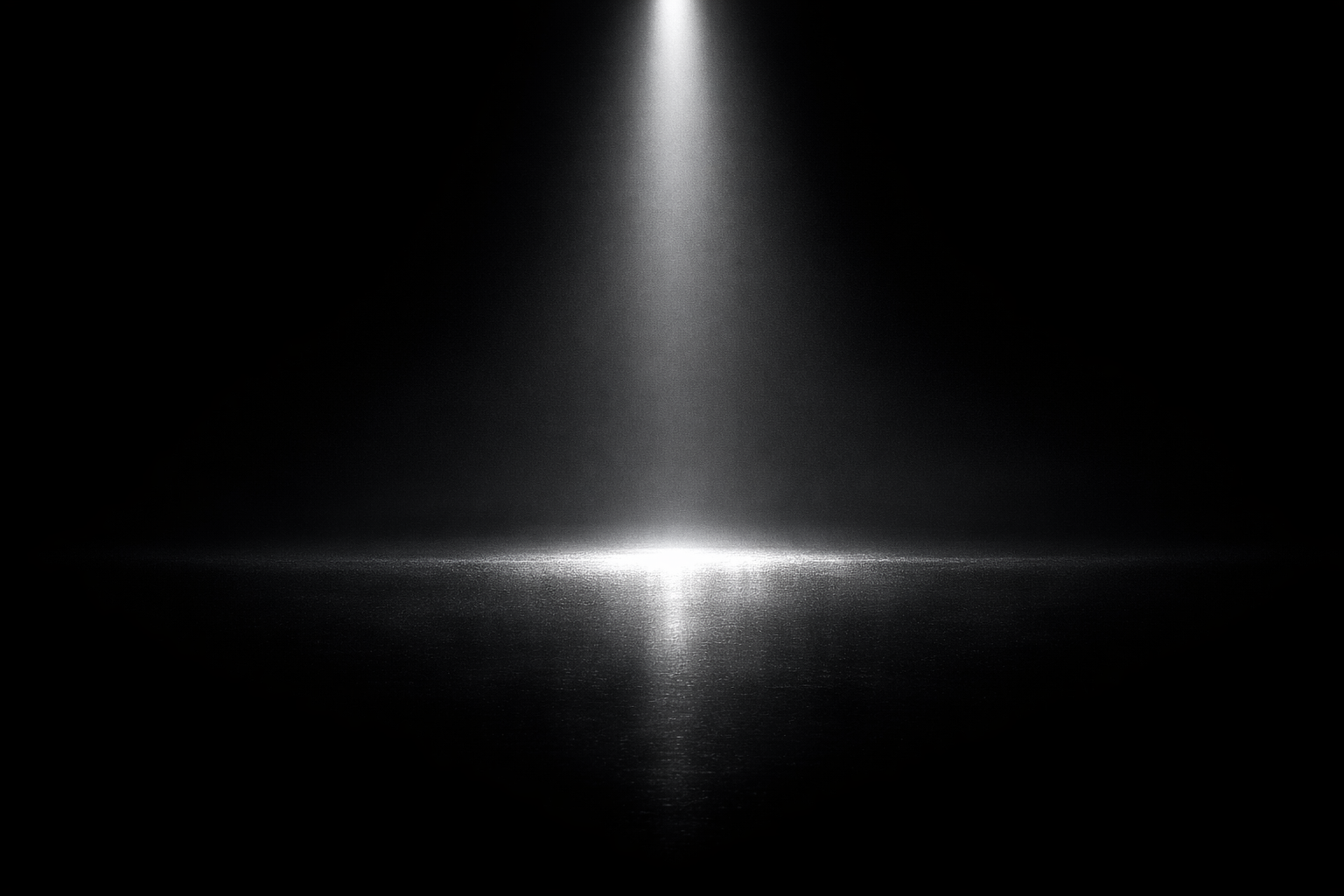 Minimal spotlight illuminating a reflective floor in a dark space, representing clarity and practical freedom