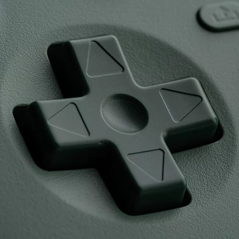 Close-up of a control pad with directional buttons on a dark green surface