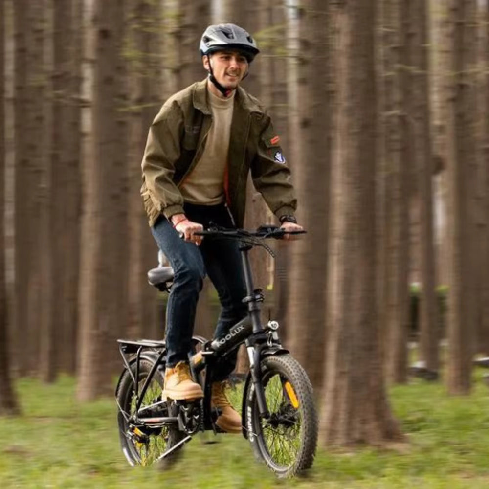 Man riding a KOOLUX X11S electric bicycle in a forest