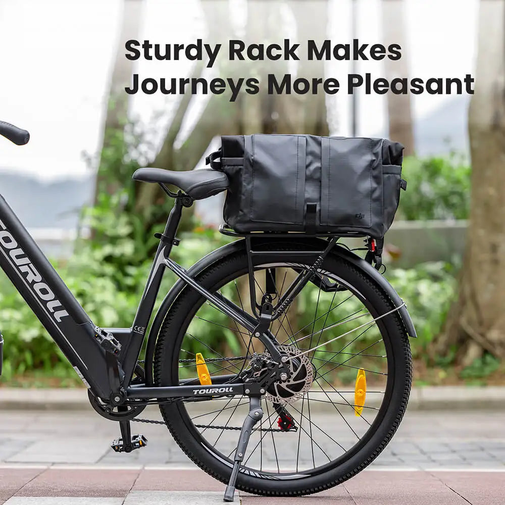 Electric Bicycle with a black rack and bag on a paved path with greenery in the background