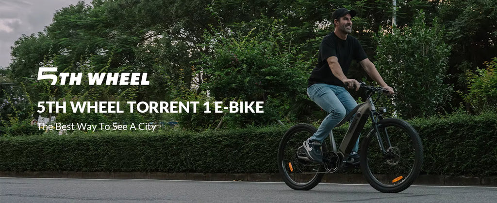 Person riding a 5th Wheel e-bike on a city street with greenery in the background