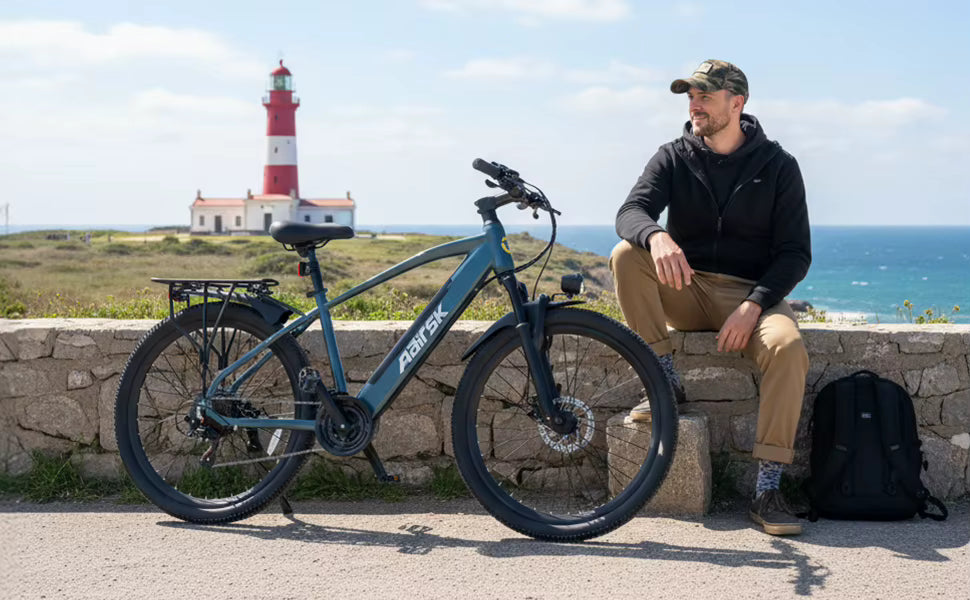 Scenic coastal lifestyle photograph of a rider resting next to the electric bike near a lighthouse