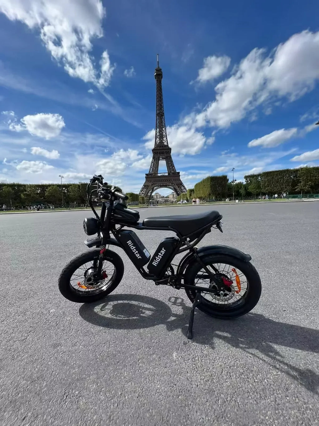 Black Electric bike in front of the Eiffel Tower on a clear day