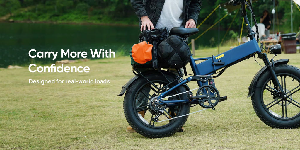 Blue electric bike with cargo bags on a grassy field, promotional text 'Carry More With Confidence'.