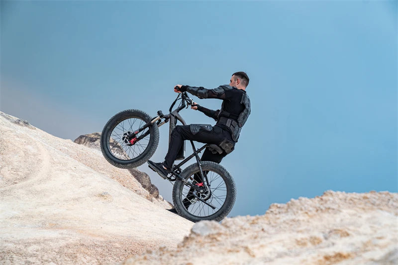 Rider wearing protective gear riding a LANKELEISI MG740PLUS full suspension fat tyre electric mountain bike through a rocky trail.