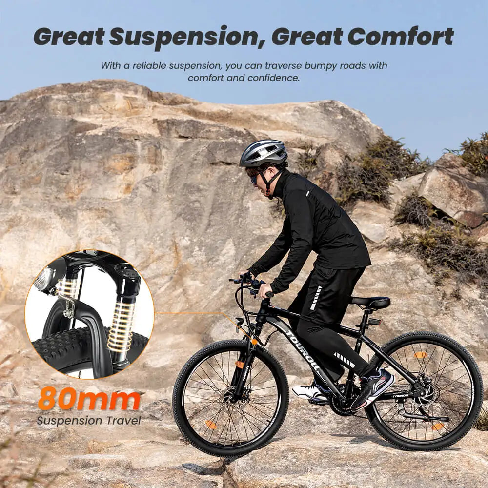 Person riding an electric bicycle on rocky terrain with promotional text about suspension and comfort.