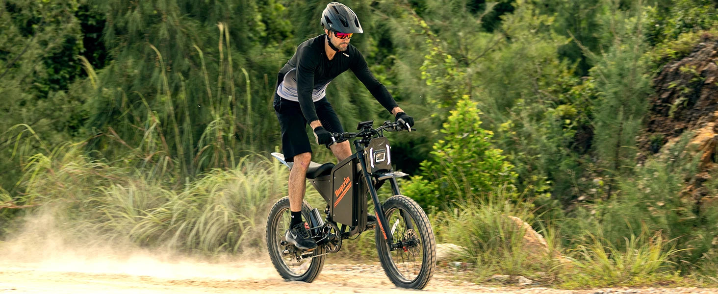 Person riding an electric bike on a dirt trail with greenery in the background