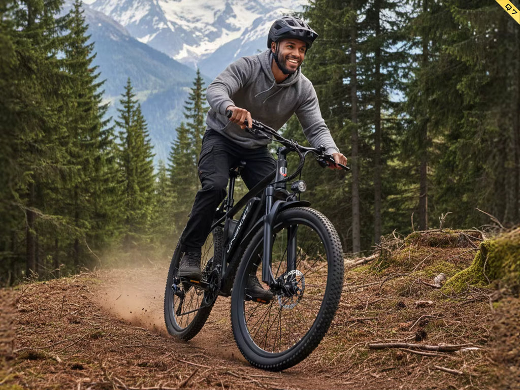 Man riding a Aairsk Q7 mountain bike on a trail with mountains and trees in the background