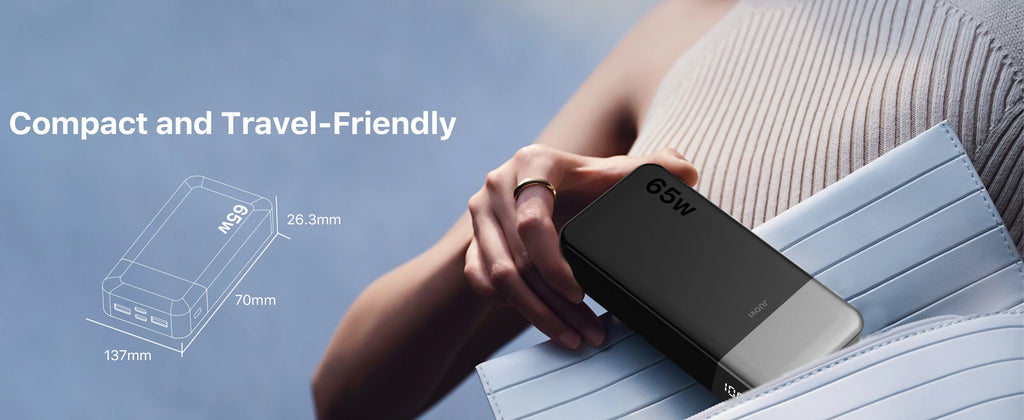A person holds a compact black 65W portable power bank against a light blue striped notebook. The image includes marketing text reading 'Compact and Travel-Friendly' and a small dimension diagram of the power bank.