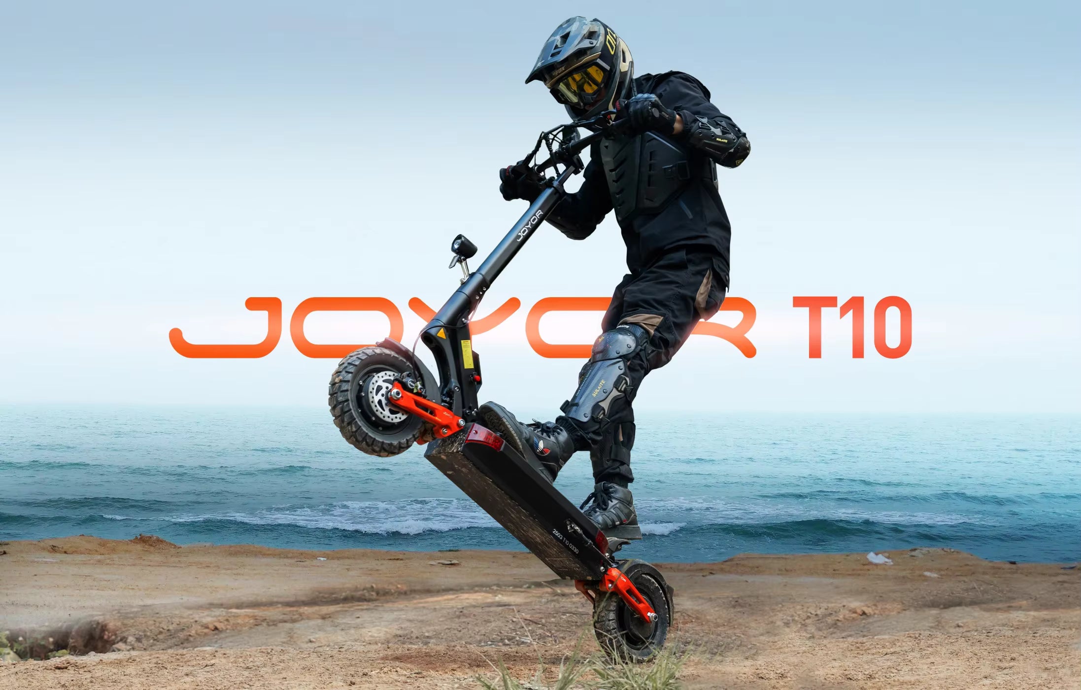 Person performing a trick on a Joyor T10 scooter by the ocean.