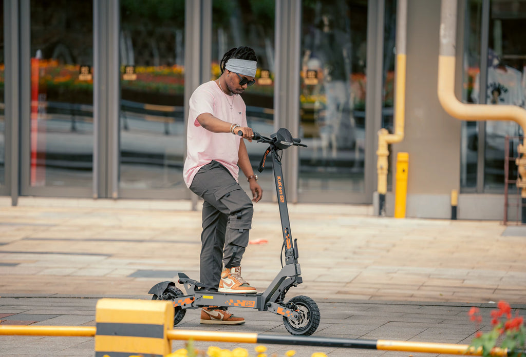 Person riding an electric scooter on a sidewalk with a building in the background