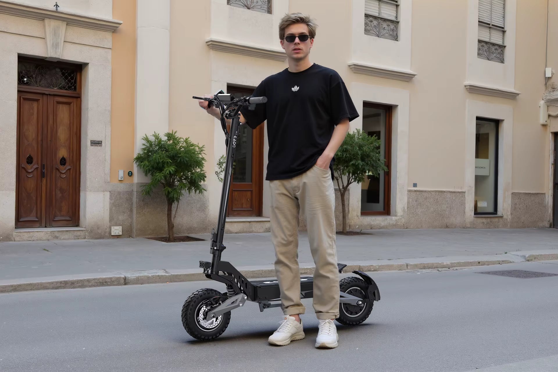 Person standing next to a folding electric scooter on a city street.