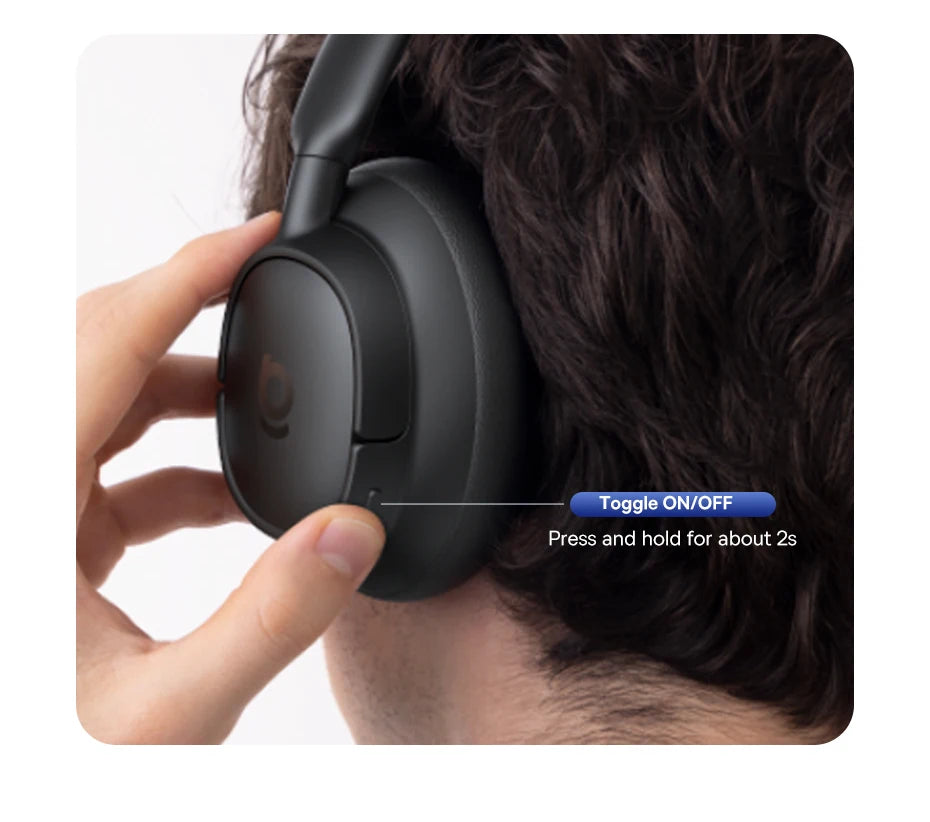 Person wearing black headphones with a hand toggling the on/off switch.