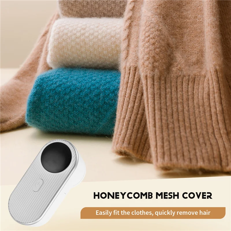 Rechargeable fabric shaver placed beside folded wool and cashmere sweaters showing honeycomb mesh cover design for quick lint removal and smooth garment finish.