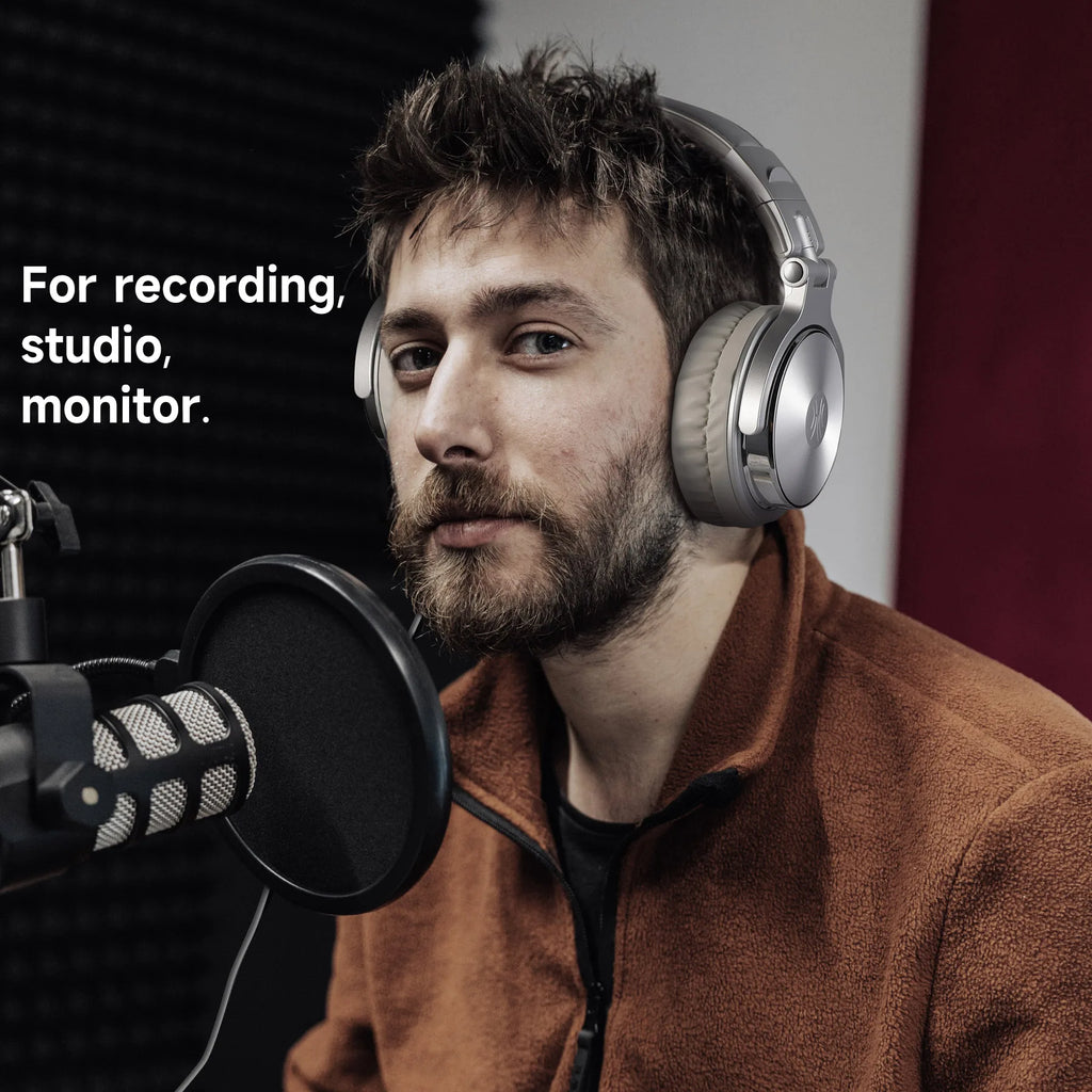 Man wearing headphones and speaking into a microphone in a studio setting.