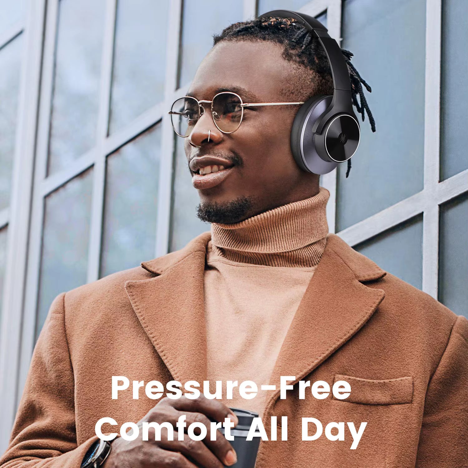 Man wearing OneOdio A10 Hybrid ANC Over-Ear Bluetooth headphones with text 'Pressure-Free Comfort All Day' against a windowed building background