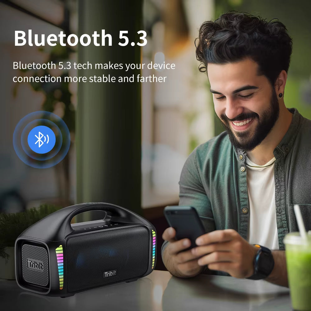 Man using a smartphone with a Tribit StormBox Blast  Bluetooth speaker on a table, emphasizing Bluetooth 5.3 technology.