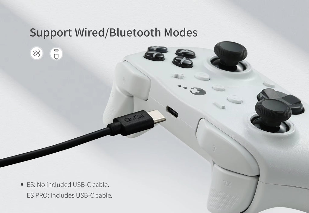 GuliKit ES Controller in white finish showing USB‑C cable connection. Promotional graphic text reads “Support Wired/Bluetooth Modes.” Bluetooth and cable icons highlight dual connectivity options. Note below specifies ES model excludes USB‑C cable, while ES Pro includes it.