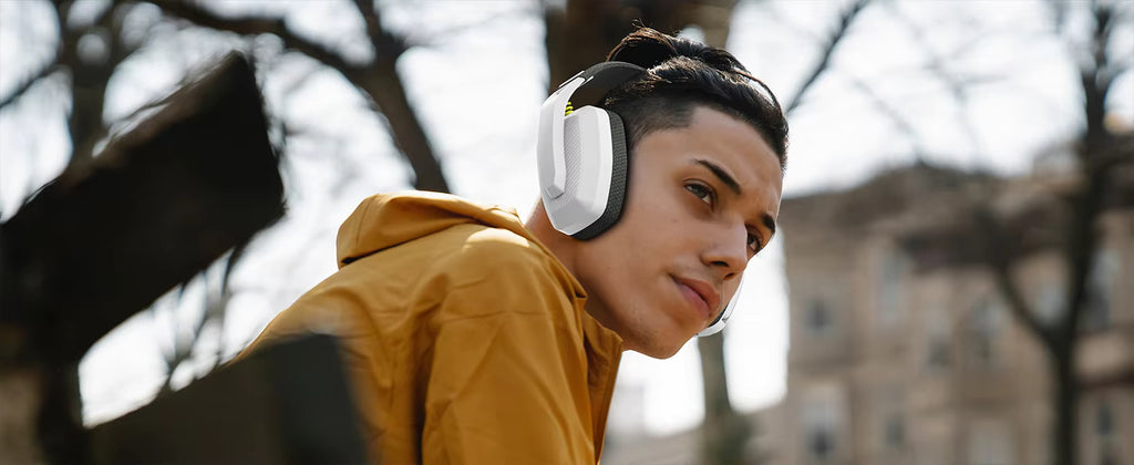Lifestyle photograph of a person wearing the headset outdoors in an urban setting