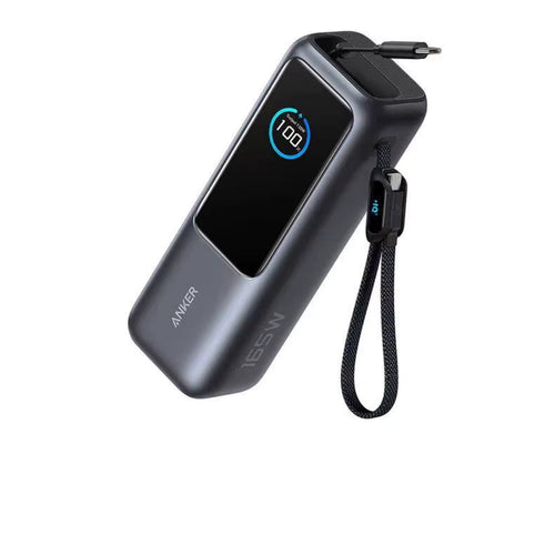 Anker 165W power bank shown in metallic grey with digital display reading 100 % full, built‑in retractable USB‑C cable extended and wrist strap attached, highlighting compact high‑capacity design for fast portable charging.