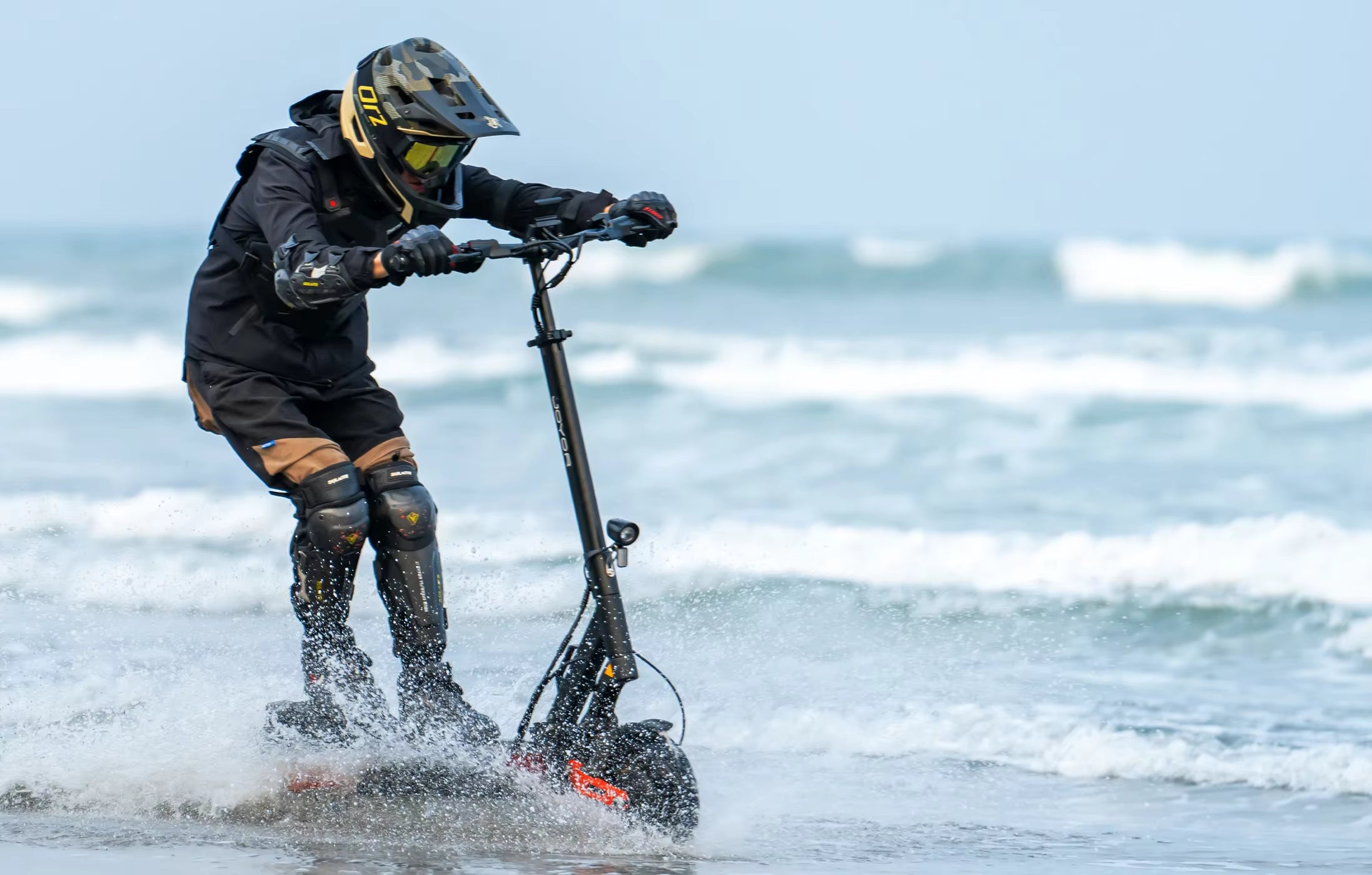 Person riding a water scooter on a beach with ocean waves in the background