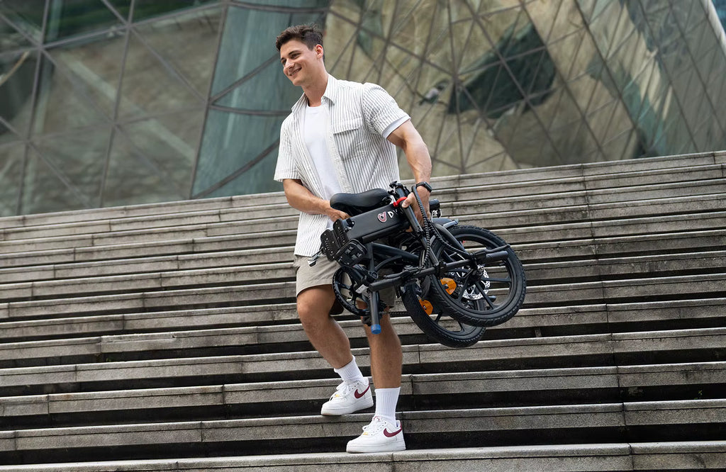 Man holding a folded DYU A1F Pro Folding Electric Bike e-bike on outdoor steps with modern architecture in the background