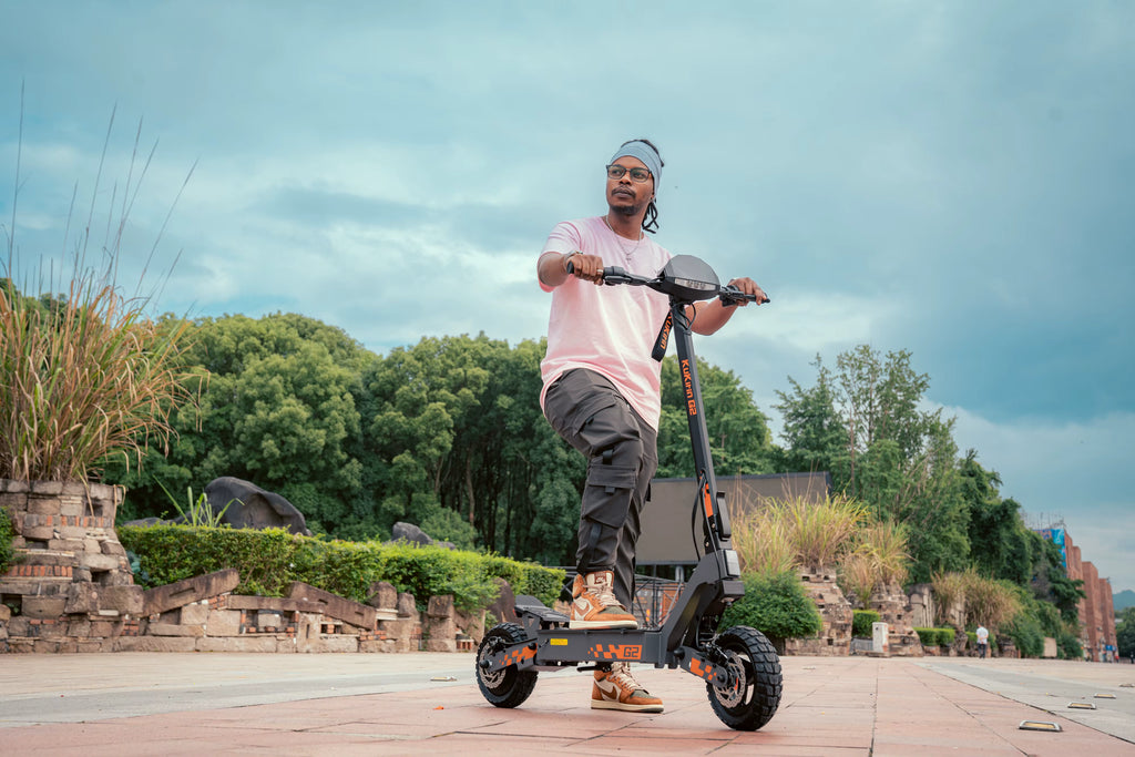 Man riding an electric scooter outdoors with trees and sky in the background