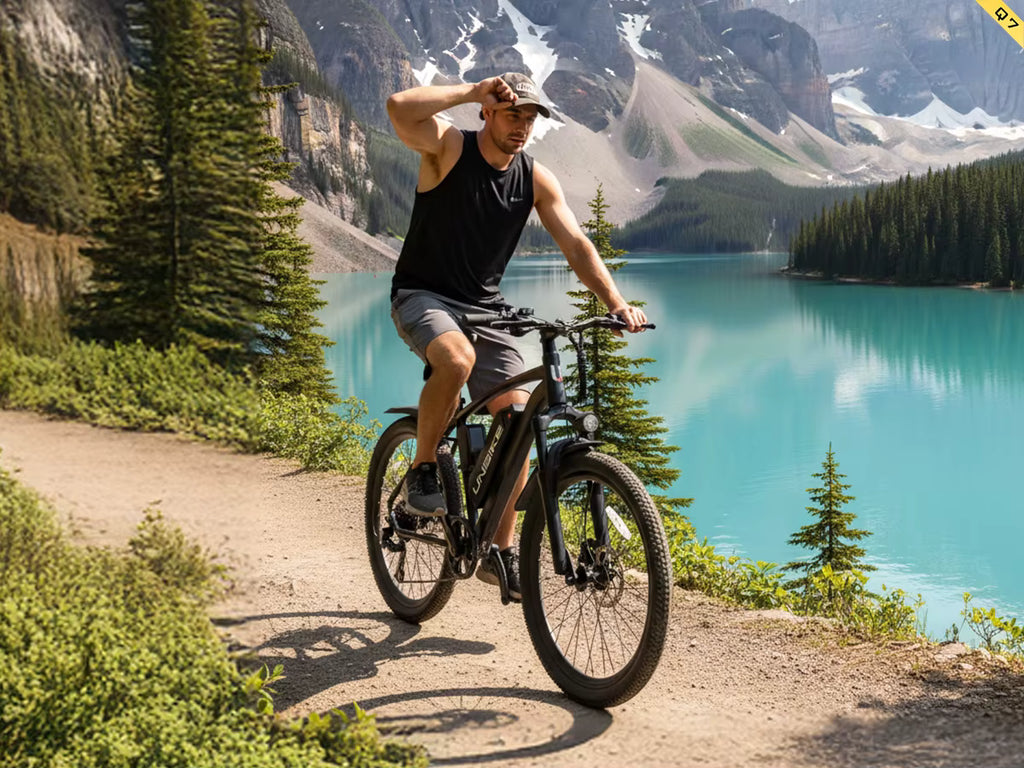 Man riding an Aairsk Q7 electric  bicycle on a trail with a scenic mountain lake in the background