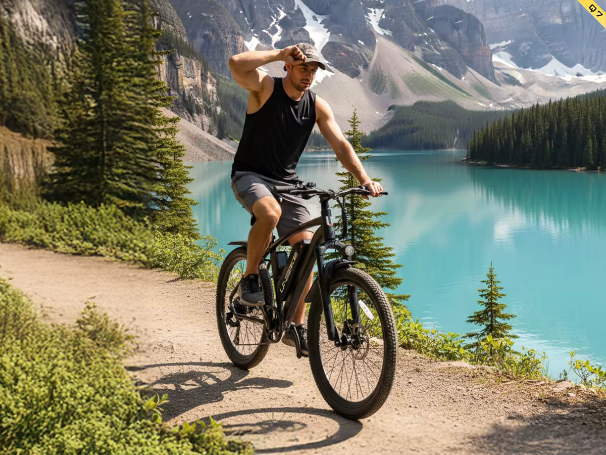 Man riding an Aairsk Q7 electric  bicycle on a trail with a scenic mountain lake in the background