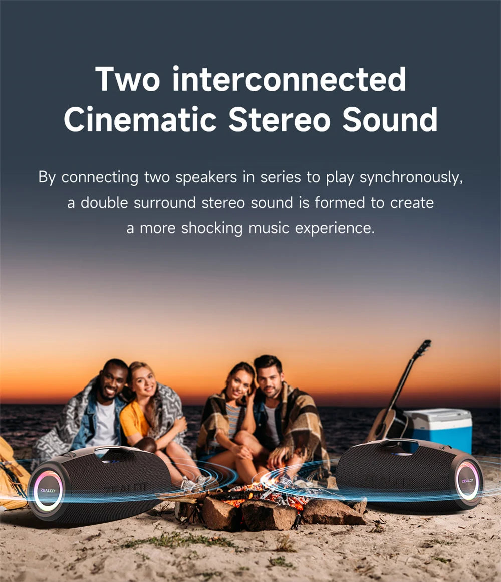 Two interconnected bluetooth Zealot portable speakers on a beach with people around, sunset in the background.