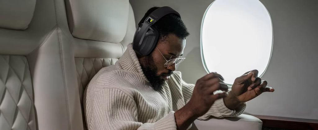 Lifestyle photograph of a person using the headset for mobile media consumption on a train or plane