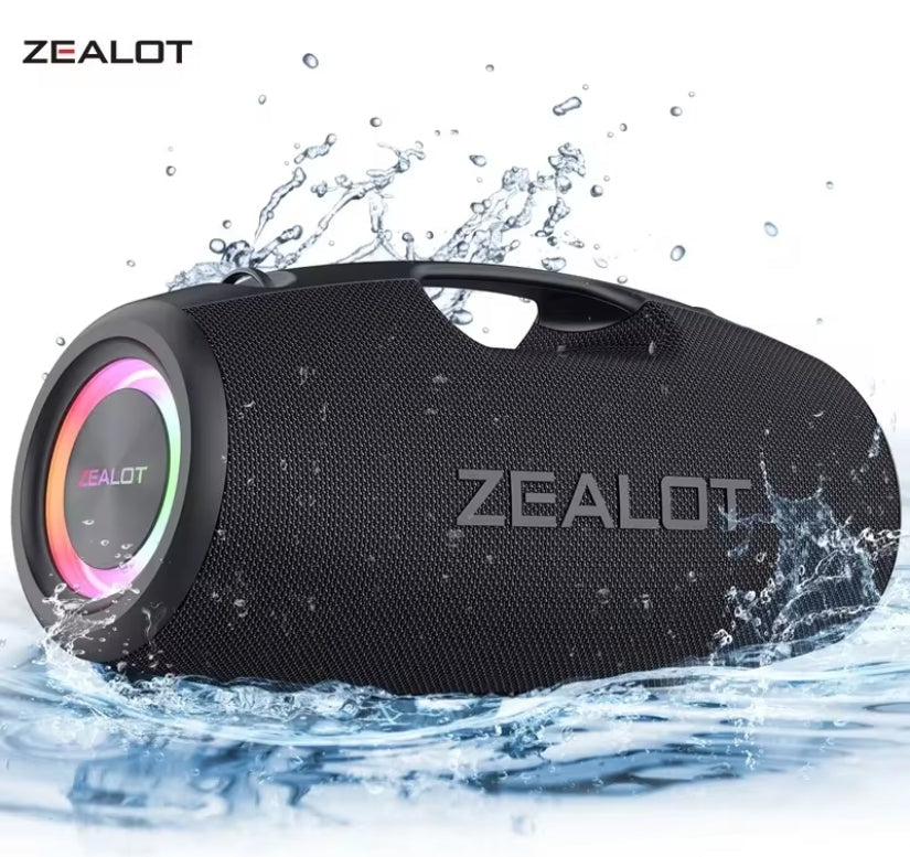 A black Zealot portable Bluetooth speaker with a water-resistant design, shown partially submerged in splashing water against a white background.