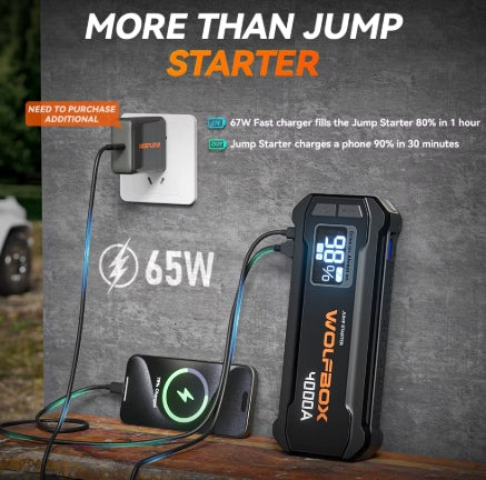  WOLFBOX jump starter with smartphone and plug on a wooden surface.