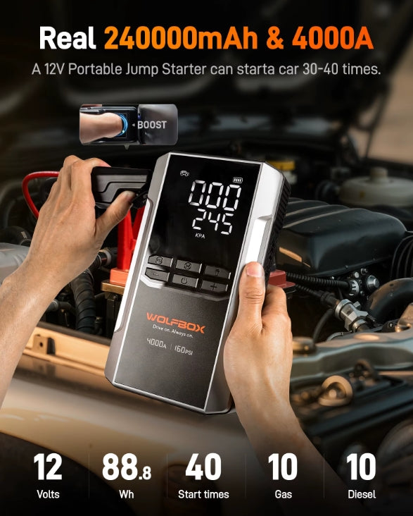 Portable jump starter being used on a car with digital display and branding.