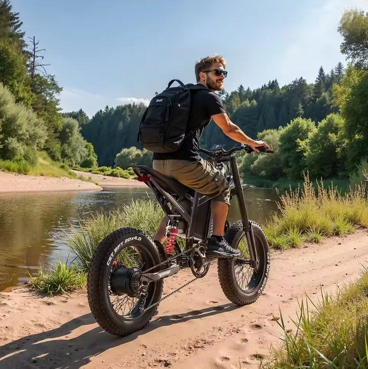 Man riding an electric bike along a scenic trail with trees and water in the background