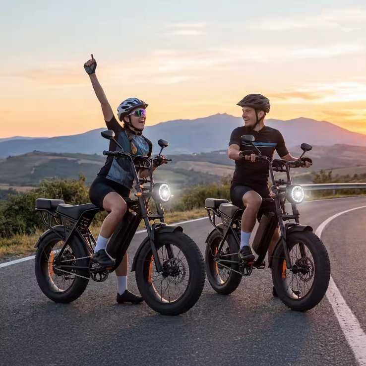 Two riders on Aairsk 250W fat tyre electric bikes at sunset on mountain road.