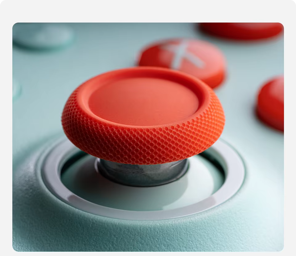 Close-up of a red joystick on a gaming controller with a blurred background