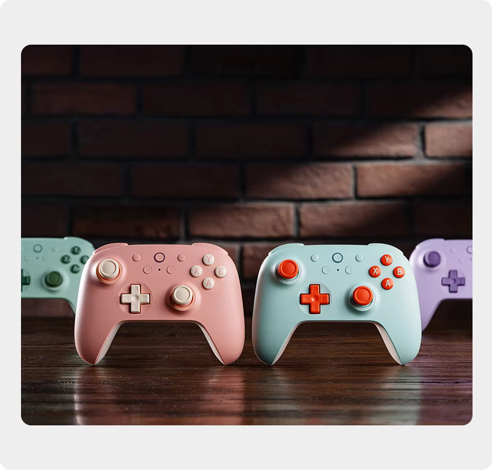 Four colorful gaming controllers on a wooden surface with a brick wall background