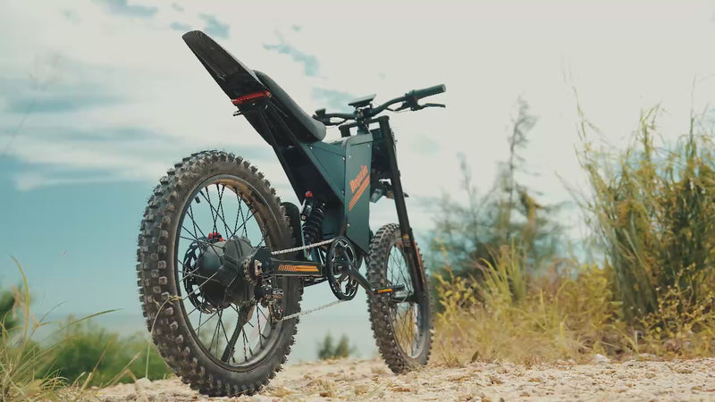 Person riding an electric bike in a mountainous area and also riding an electric bike on a beach. Person is performing wheelies and showing how versatile the bike is. The video also shows different views and angles of this e-bike.