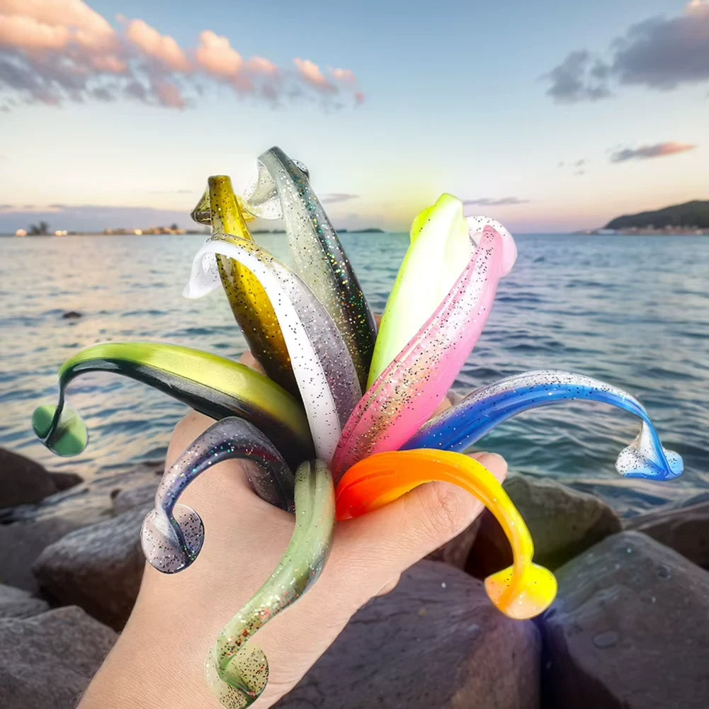Colorful fishing lures held by a hand with a scenic ocean background