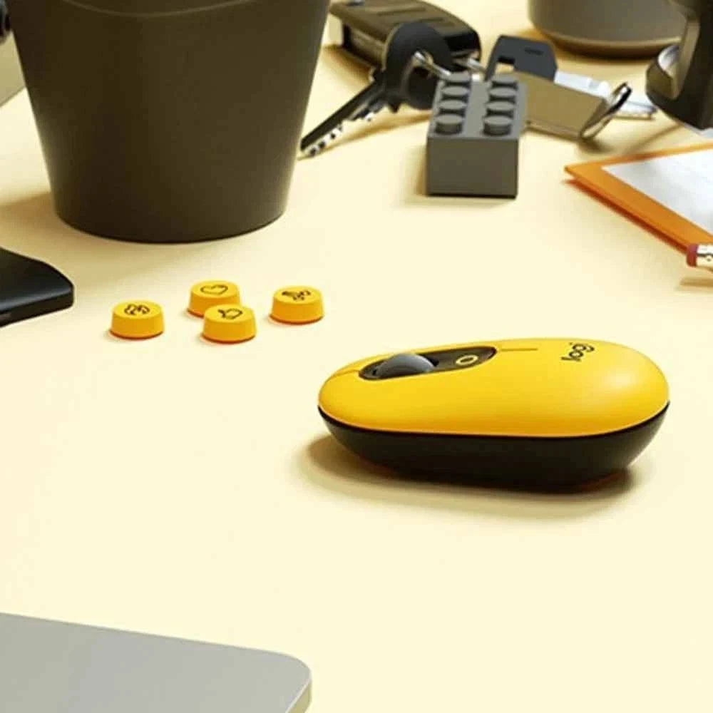 Yellow and black computer mouse on a desk with office items