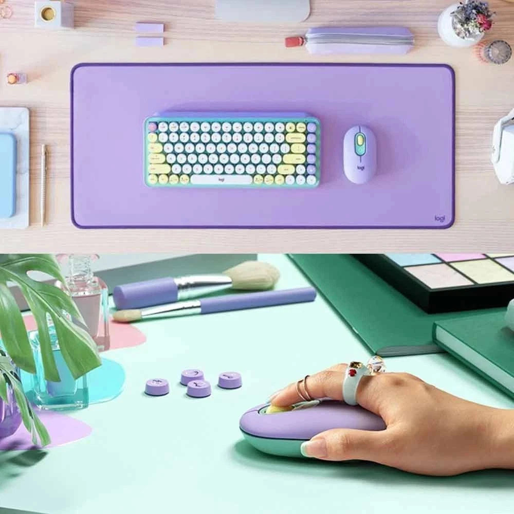 Colorful keyboard and mouse on a  purple mouse pad with a hand using the mouse.