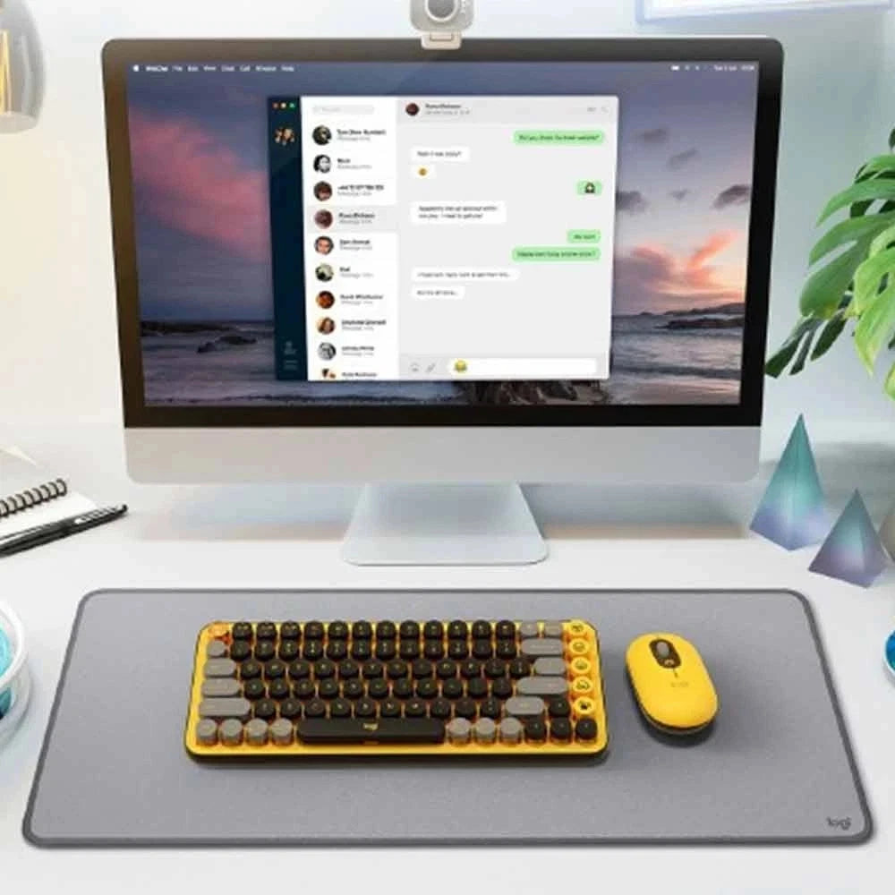 Modern computer setup with a monitor, keyboard, and yellow mouse on a desk.