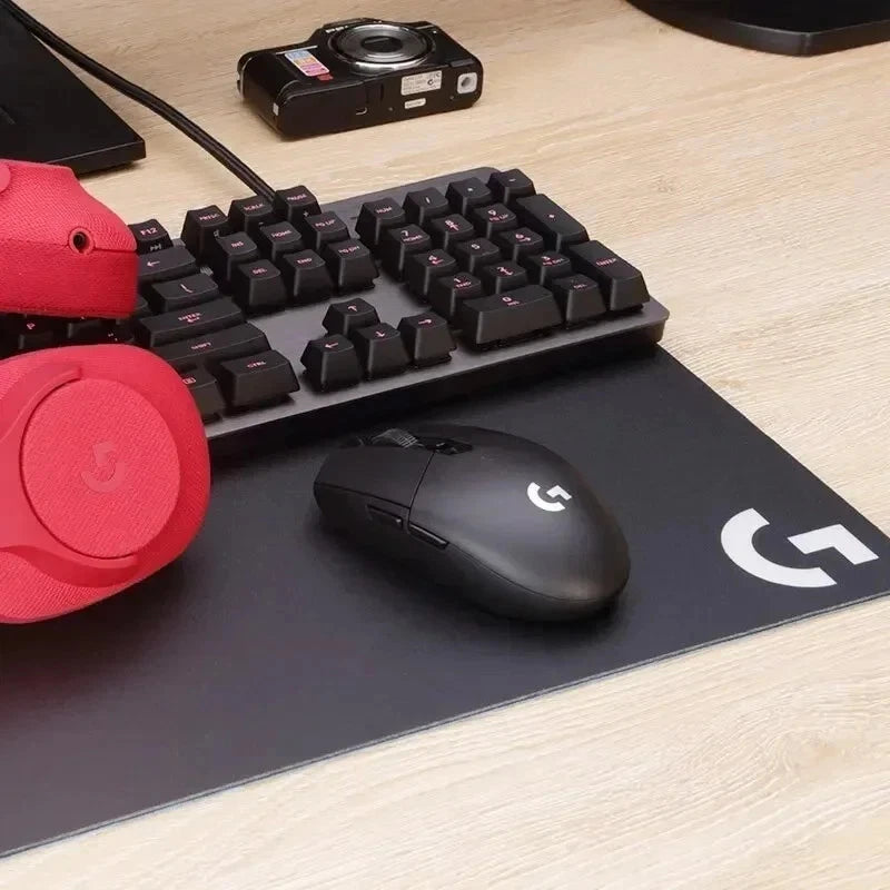 Gaming keyboard, mouse, and headset on a desk with Logitech branding.